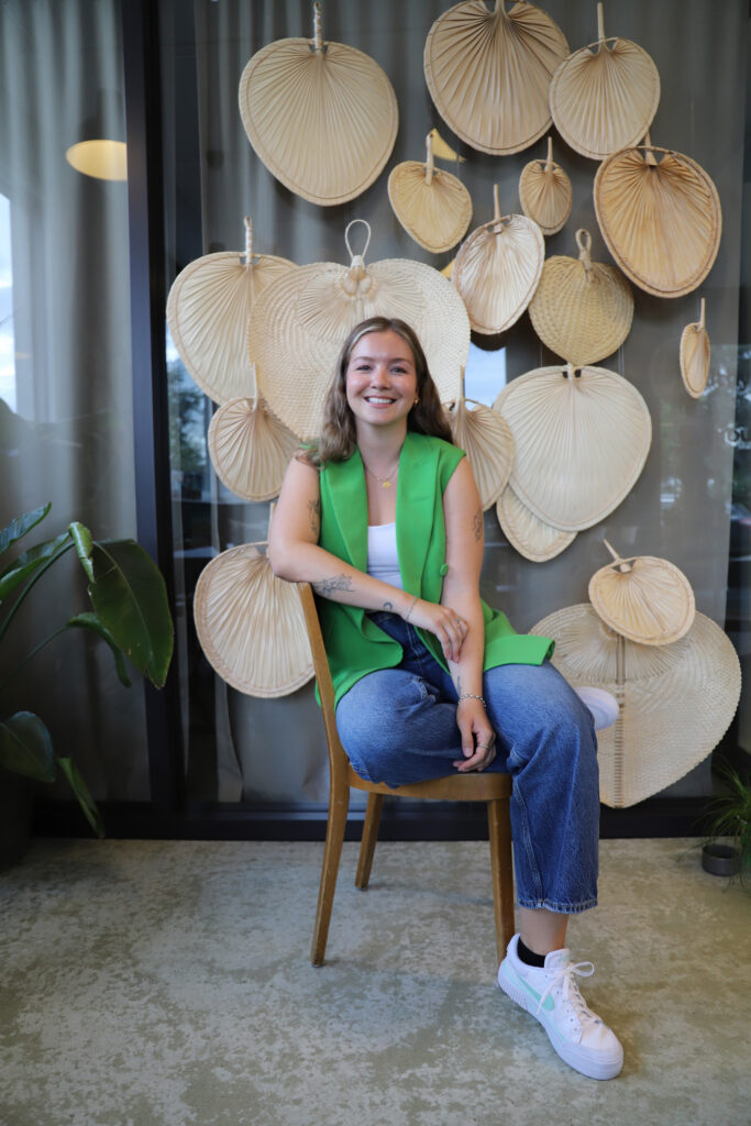 Woman sitting and smiling in front of decorative wall fans