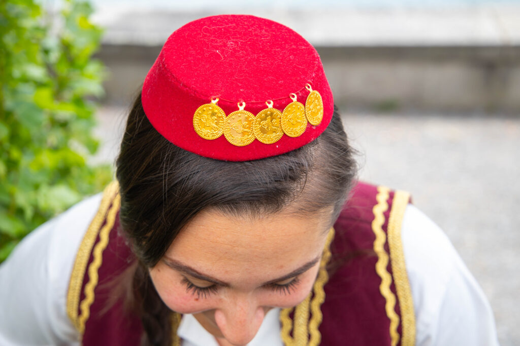 Rote traditionelle Mütze mit goldenen Münzen